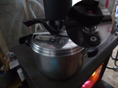 Pressure cooker - note red button has popped up to prevent the lid being removed while cooking.