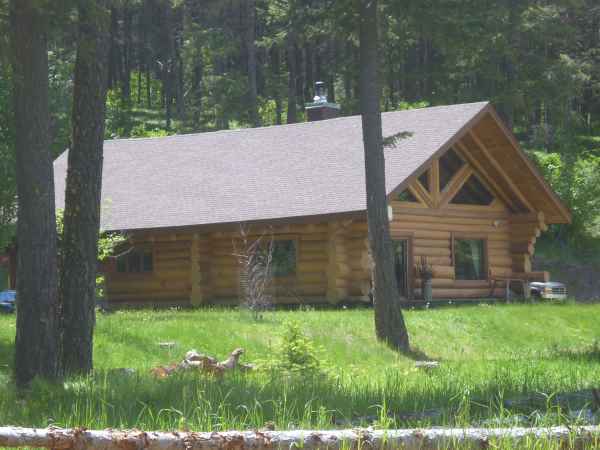 Hand built log home surrounded by woods